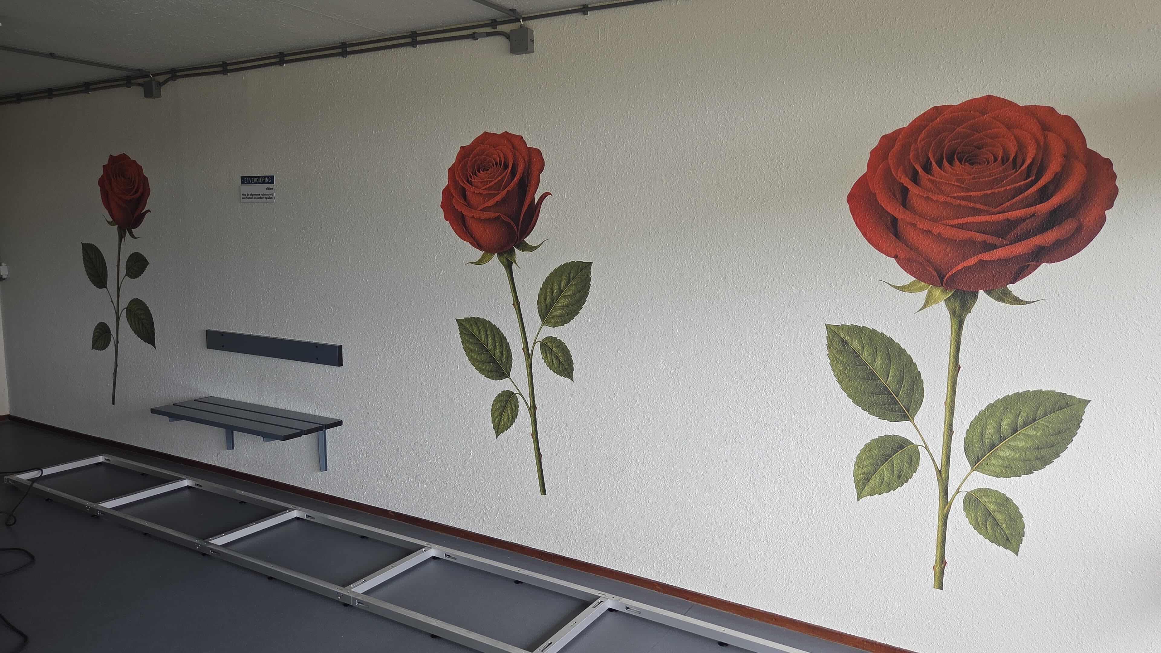 Rode rozen als herkenbare muurvisual in een hal van Elkien